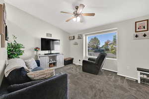 Living area featuring carpet floors, window, and ceiling fan