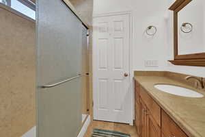 Bathroom featuring vanity, a stall shower, and light tile patterned floors