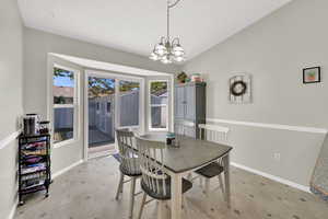 Dining room featuring a chandelier, box bay windows, and back door with pet door