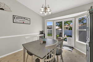 Dining room featuring a chandelier, box bay windows, and back door with pet door