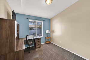 Bedroom featuring carpet and baseboards