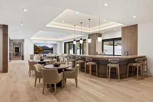 Dining room with light wood-style flooring and a tray ceiling