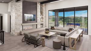 Living area featuring beam ceiling, a stone fireplace, and light wood-style flooring