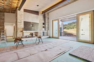 Living room featuring a high ceiling and a wooden ceiling with exposed beams