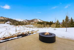 Snow covered patio featuring a mountain view and a patio area
