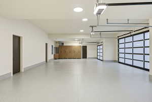 Garage featuring recessed lighting, a garage door opener, and a heating unit