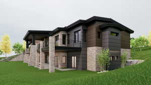 Back of house featuring a patio area, a yard, stone siding, and a balcony