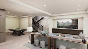 Living room featuring a tray ceiling, light wood finished floors, recessed lighting, and stairway