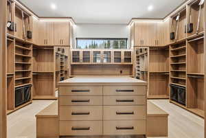 Walk in closet with light wood-style flooring