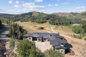 View of subject property featuring a mountain backdrop and a heavily wooded area