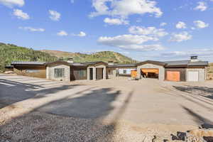 Prairie-style home featuring stone siding, a mountain view, and a chimney