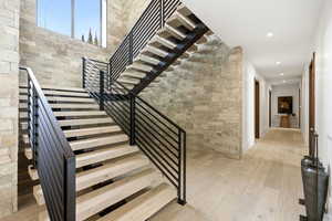 Staircase with wood-type flooring and recessed lighting