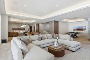 Living area with light wood-style flooring and a tray ceiling