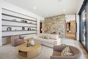 Living room featuring recessed lighting, light wood-type flooring, and built in shelves