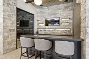 Indoor dry bar featuring light wood-style floors and wood ceiling