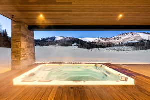 Snow covered pool with a deck with mountain view
