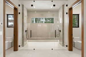 Bathroom with plenty of natural light, a shower stall, and tile patterned floors
