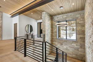 Stairway featuring wood finished floors, wood ceiling, recessed lighting, and an accent wall
