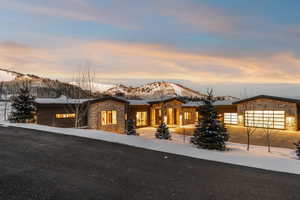 View of front of house with stone siding, a mountain view, and a garage
