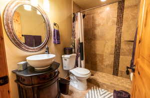 Bathroom featuring a textured wall, a stall shower, and vanity