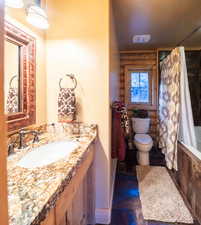 Bathroom featuring tiled shower / bath, vanity, and a textured ceiling
