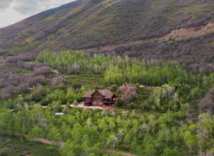Aerial view of property and surrounding area with a forest
