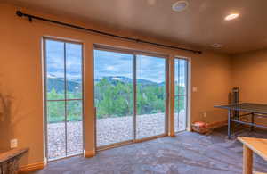 Doorway to outside with a mountain view, plenty of natural light, and carpet