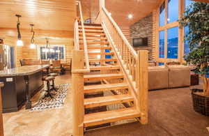 Staircase with log walls, wood ceiling, high vaulted ceiling, and carpet