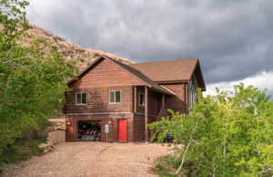 View of property exterior featuring gravel driveway and a shingled roof