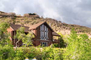 Rear view of property with log siding and a shingled roof