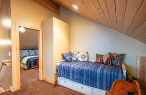 Carpeted bedroom with wood ceiling and lofted ceiling
