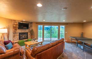 Living room featuring a textured ceiling, a fireplace, carpet floors, and recessed lighting