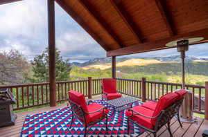 Deck with a mountain view and a grill
