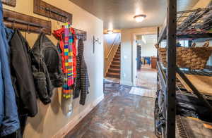 Mudroom featuring a textured ceiling and baseboards