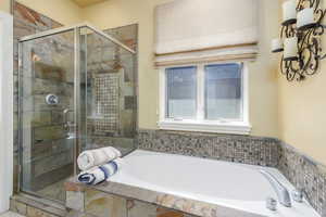 Full bath with a stall shower and a bath