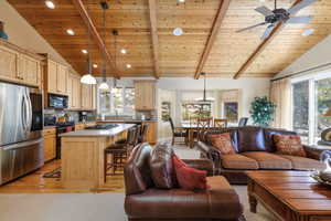 Living room featuring a wood ceiling with exposed beams, light wood-style floors, high vaulted ceiling, and a ceiling fan