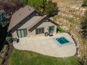 Back of house featuring stone siding and a patio area