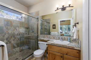 Full bath featuring a shower stall, vanity, backsplash, and ensuite bathroom