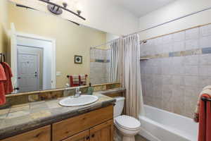 Bathroom with shower / bath combination with curtain and vanity