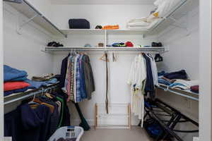 Walk in closet with light colored carpet