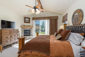 Bedroom with access to exterior, carpet floors, ceiling fan, and a fireplace