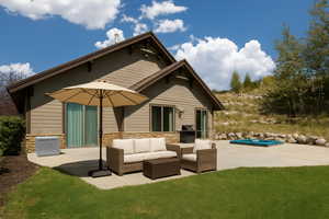 Back of property with a patio area, stone siding, an outdoor living space, and an outdoor pool