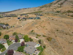 Aerial view of property and surrounding area featuring nearby suburban area and mountains