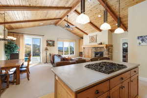 Kitchen featuring pendant lighting, a fireplace, open floor plan, black gas cooktop, and a kitchen island
