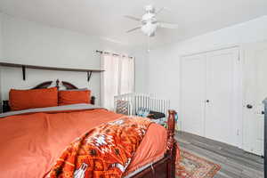 Bedroom with a ceiling fan, wood finished floors, and a closet