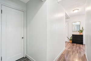 Hallway featuring dark wood finished floors and baseboards