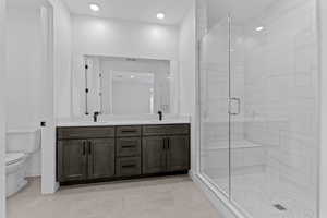 Bathroom with a shower stall, double vanity, light tile patterned flooring, and recessed lighting