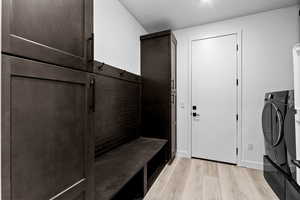 Mudroom featuring light wood-type flooring and washing machine and clothes dryer