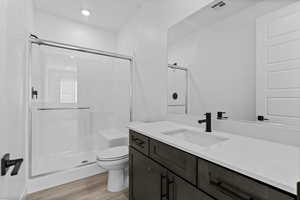 Bathroom featuring a shower stall, vanity, and light wood-style flooring