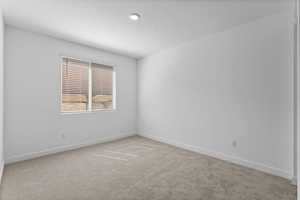 Unfurnished room featuring light carpet and baseboards